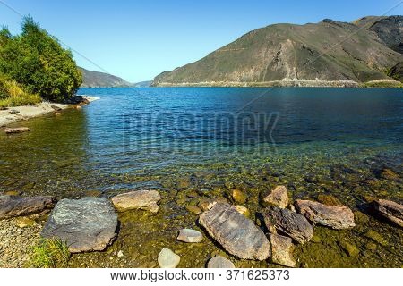 The beauty of the South Island. New Zealand Southern Alps. The surroundings of the city of Cromwell among mountains and lakes. The concept of ecological, landscape and photo tourism