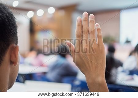 Student Audience Raising Hand While Speaker On Stage At Conference To Answer Question While Speaker 