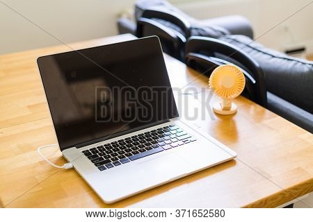 Mini Usb Fan Near Laptop. Summer Office Day. Mini Portable Cooler