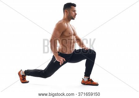 Side View Of Muscular Caucasian Shirtless Bodybuilder Stretching Legs On Floor Isolated On White Bac