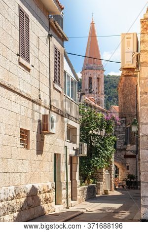View Of An Old Greek Style Narrow Street In Starigrad, Hvar Leading To The Church Belltower Seen Ris