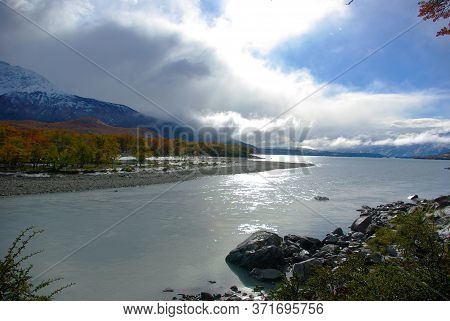 Beautiful River Postcard With Autumn Trees And Snowy Mountains On A Sunny Day And Clouds In Patagoni