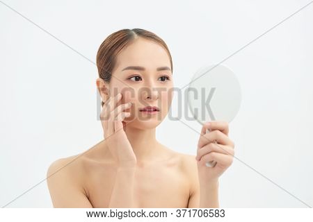 Young Asian Woman With Problem Face Looking At The Mirror  Over White Background.