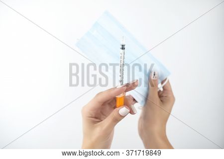 Womans Hands Holding Medical Mask In One Hand And Siringe In Another On Isolated White Background, H