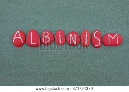 Albinism Is A Congenital Disorder Name Composed With Red Colored Stone Letters Over Green Sand