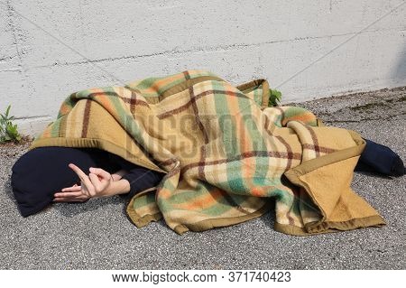 Homeless Man Is Angry And Makes A Bad Gesture With The Middle Finger Of His Hand From Under A Dirty 
