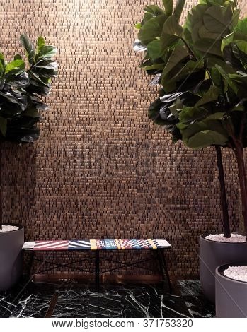 Cozy Living Room Corner With Multi Color Rattan Sofa And Artificial Plant With Wood Sheet Wallcoveri