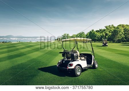 Golfcars Riding On Green Golf Course. Outdoor Sport Luxury Activity