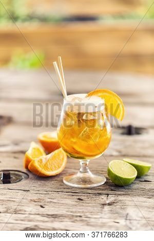 Beer Lemonade In A Glass With Freshly Cut Orange, Ice And Paper Straws.