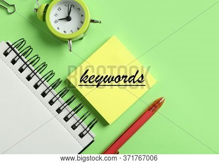 Modern Office Accessorises And Note With Text Keywords On Green Background, Flat Lay