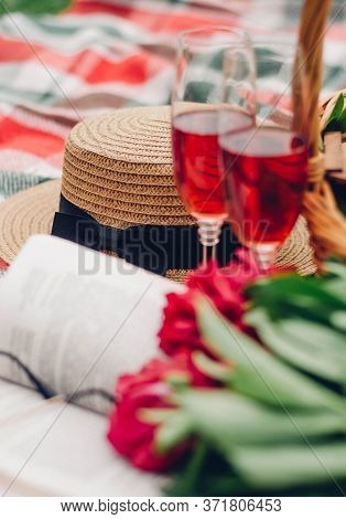 Mood reading a picnic book under a glass of red wine