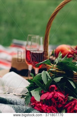 Mood reading a picnic book under a glass of red wine