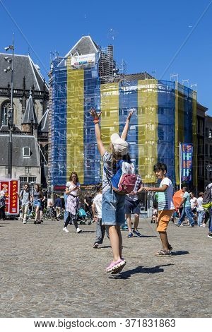 Amsterdam, Netherlands - July 02, 2018: Children Catch Soap Bubbles In The Central Dam Square In Ams