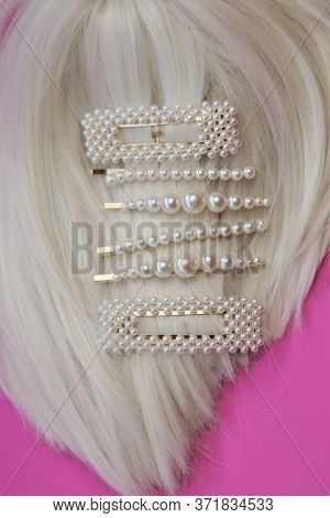 Pearl Hair Clips On Blond Hair . Fashionable Hair Accessories. Hairpin With Pearls On A Bright Pink 