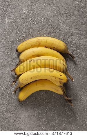 Ripe Bananas On Gray Concrete Background. Interior Photo. Photoart.