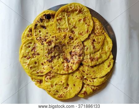 Closeup Of Yellow Color Traditional Dal Obbattu Or Holige In A Plate Isolated On White Background