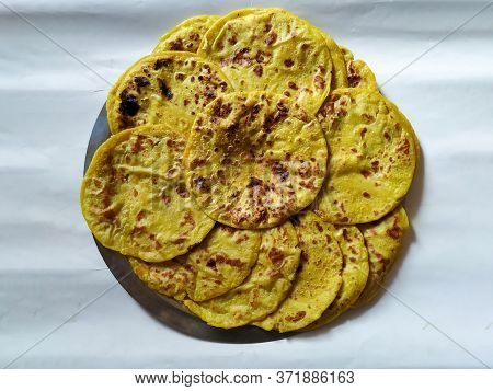 Closeup Of Yellow Color Traditional Dal Obbattu Or Holige In A Plate Isolated On White Background