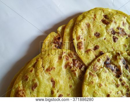 Closeup Of Yellow Color Traditional Dal Obbattu Or Holige In A Plate Isolated On White Background