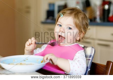 Adorable Baby Girl Eating From Spoon Mashed Vegetables And Puree. Food, Child, Feeding And People Co