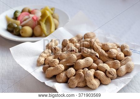 Olives Pepper And Peanuts On A Plate