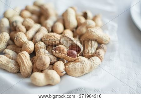 Peanuts With Shell And Peanuts Peeled On A Plate