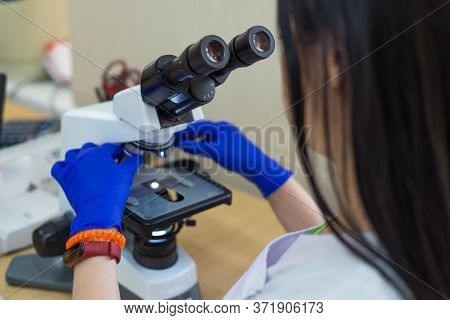 Laboratory Assistant Is Looking Through A Microscope. Close-up Doctor Laboratory Assistant Looking T