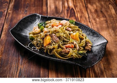 Spinach Fettuccine Pasta With Beef And Vegetables On The Wooden Table, Horizontal