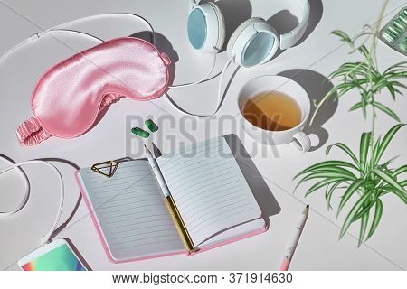 Healthy Night Sleep Creative Concept In Pink And Green. Sleep Mask, Earphones, Tea, Sleeping Pills, 