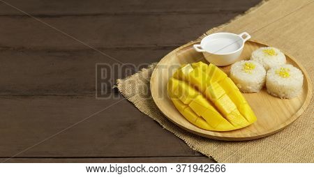 Yellow Half  Mango With Small Fork. Mango Fruit Cubes On The Wooden Table. Tropical Fruit Asia. Fres
