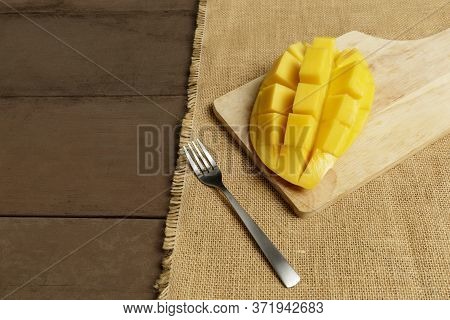 Yellow Half  Mango With Small Fork. Mango Fruit Cubes On The Wooden Table. Tropical Fruit Asia. Fres