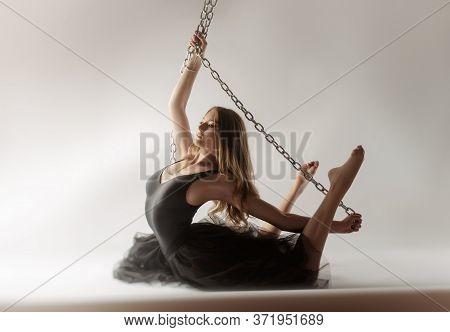 Slender Girl Dancing With A Large Chain In An Incredible Ballerina Pose