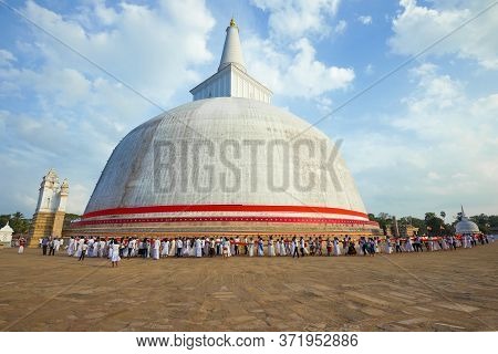 Anuradhapura, Sri Lanka - February 04, 2020: Pilgrims At The Foot Of The Ancient Stupa Of Ruwanvelis