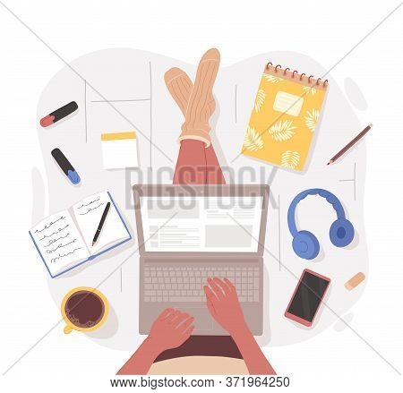 Top View Of Woman Sitting On Floor Crosslegged With Laptop On The Lap Surrounded By Stationery, Gadg