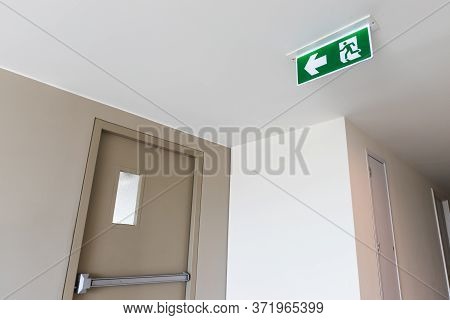 Fire Exit Sign And The Fire Exit Door That Is Closed In The Building