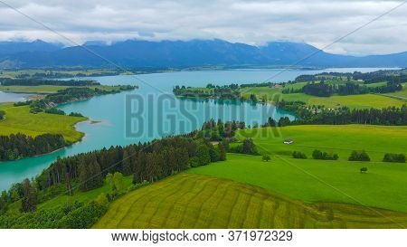 Aerial View Over Lake Forggensee At The City Of Fuessen In Bavaria Germany