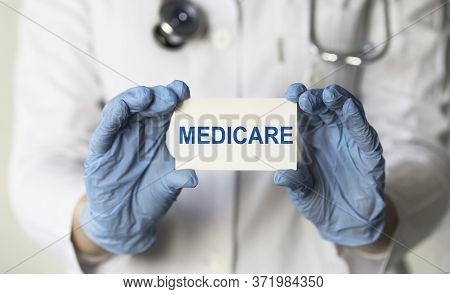 Doctor Holding A Card With Medicare, Medical Concept
