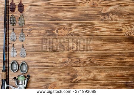 Flat Lay With Fishing Tackle, Fishing Rod And Plastic Box With Fishing Tackle And Hooks, Feeders On 