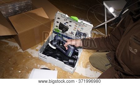 Strasbourg, France - Mar 3, 2020: Overhead View Of Worker Male Hands Unboxing Parcel Containing New 
