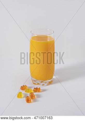 Orange Juice And Haribo Candy On White Background