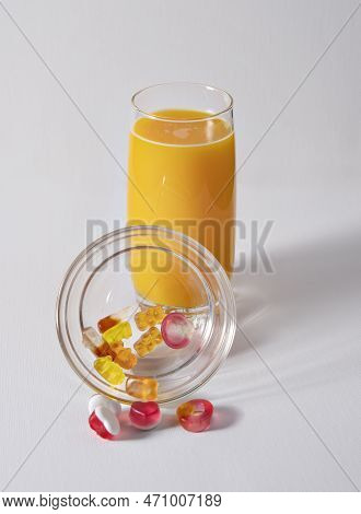 Orange Juice And Haribo Candy On White Background