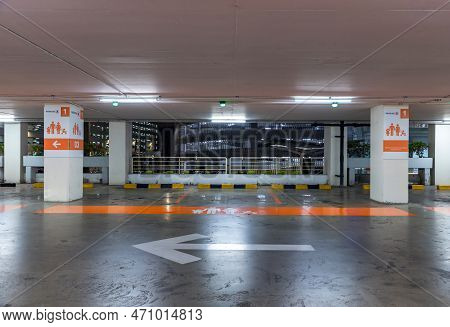 Empty Space Car Park Interior At Night. Indoor Parking Lot. Interior Of Parking Garage With Car And 