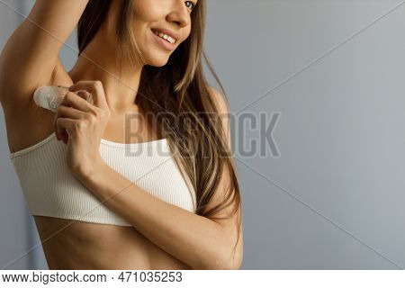 Attractive Young Woman With Long Hair In Short Top Apply Deodorant Stick To The Axilla. Close-up Of 