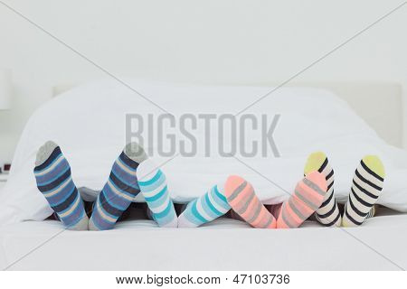 เท้าของครอบครัวในถุงที่ stripey บ้านเตียง