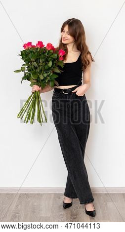 Ukraine, Khmelnytskyi, February 2023. Young Attractive Girl With A Bouquet Of Red Roses On A White B