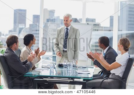 Collega's de baas applaudisseren tijdens een vergadering in de vergaderzaal