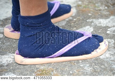 Feet Shoes With Socks And Chinhelos Stepping On The Cement Floor