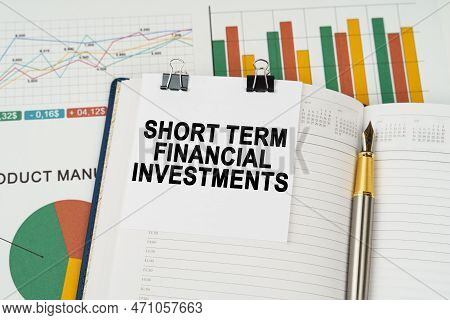 Business Concept. On The Business Charts Lies A Pen, A Notepad With Note Paper With The Inscription 