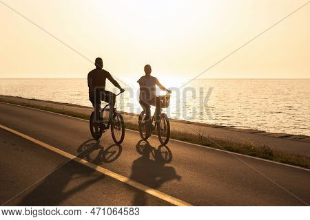 Caucasian Couple Taking Pleasure In The Ride On Beach Cruiser Bikes, Pedaling On A Wonderful Route N