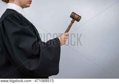 Steadfast Female Judge In A Robe Holding A Court Gavel.