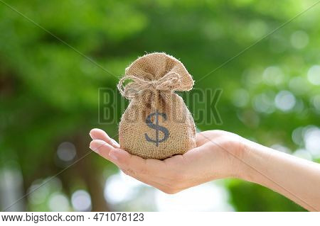 Hand Of A Woman Carrying A Purse Money .concept Saving Money And Investment Concept